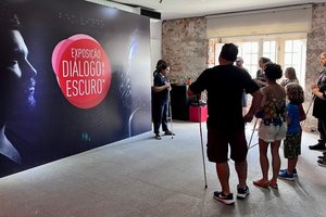 [Translate to Deutsch:] A group of people looks at the dialogue in the dark display stands