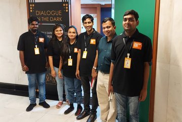 Group photo of the Dialogue in the Dark team Mumbai at the entrance to their premisis. 