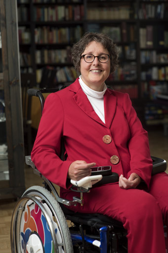 Portrait of Karen Schallert sitting in a wheelchair.