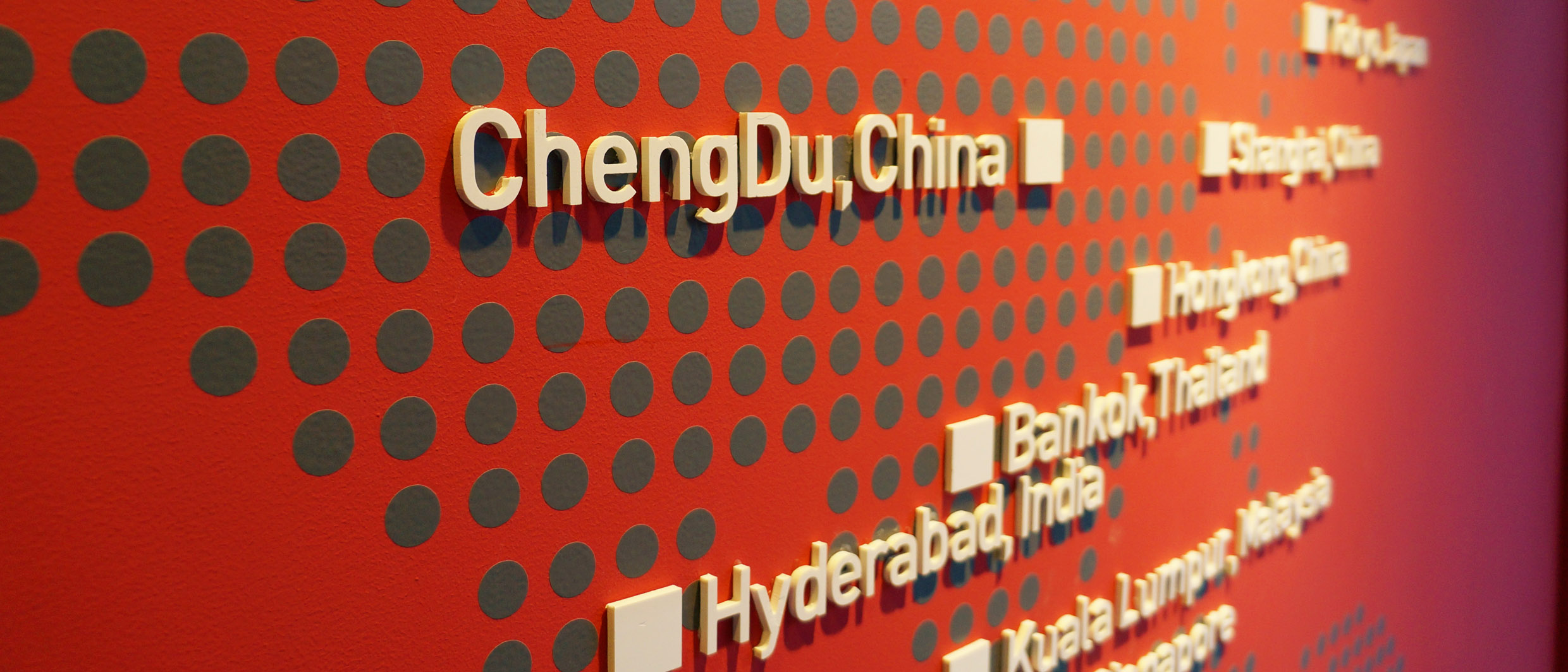 Foto einer Wand in der Dialog im Dunkeln-Ausstellung ChendDu mit einer Weltkarte in Braille-Punkten, auf der alle Dialogstandorte verzeichnet sind.